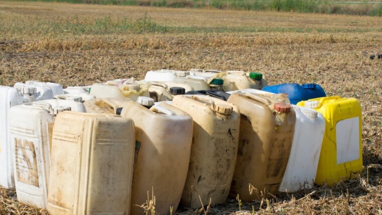 Glyphosatkanister stehen auf einem Feld